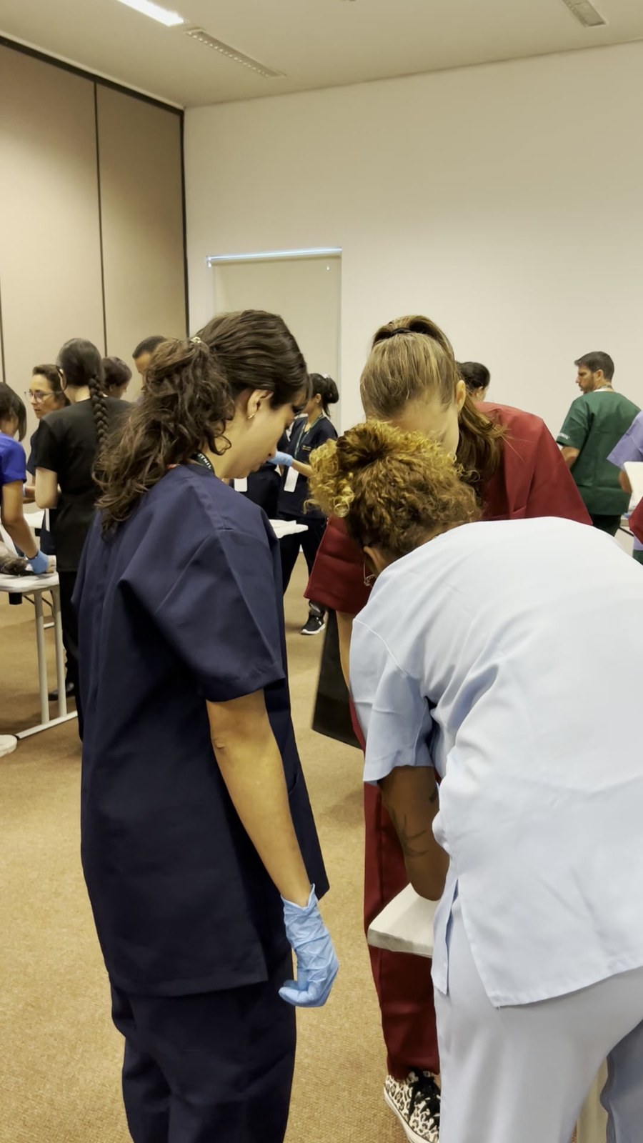 Participantes de luva em volta da bancada durante a prática